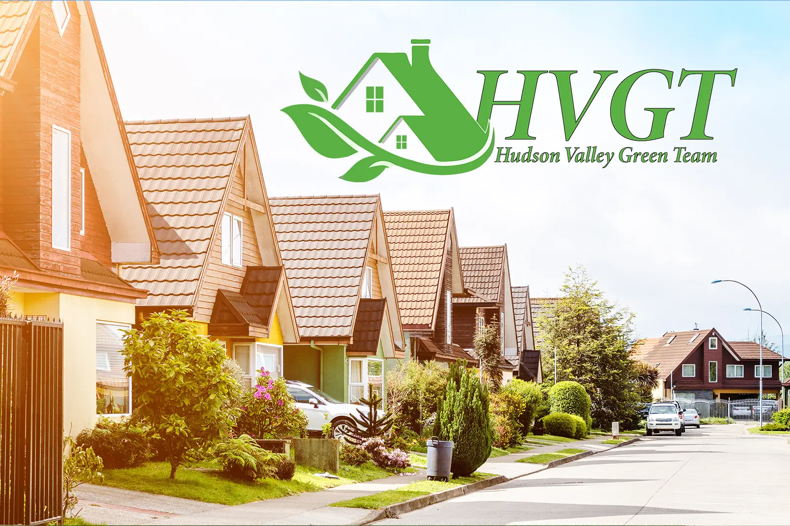 Community of houses in a row, with pointed roofs and a front garden. The image has an Hudson Valley Green Team logo placed on top.