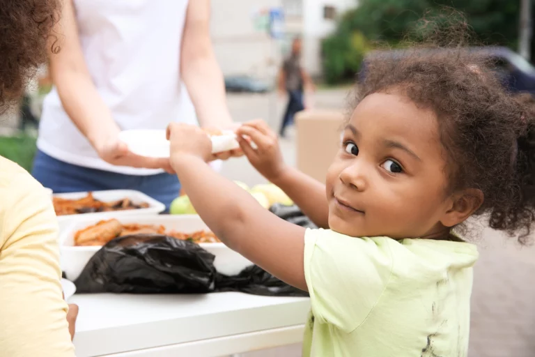 Little girl enjoying some food at a community event