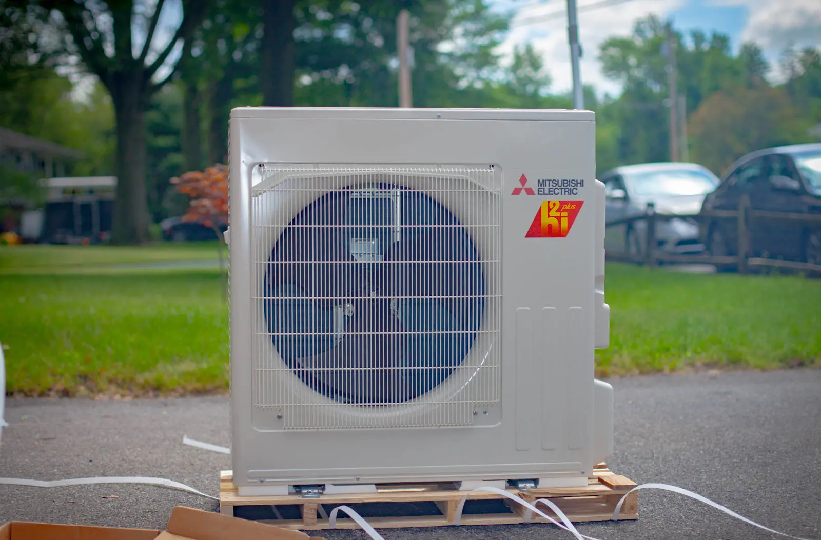 Mitsubishi Heating and Cooling Electric HVAC system on a loading crate with trees and grass in the background.