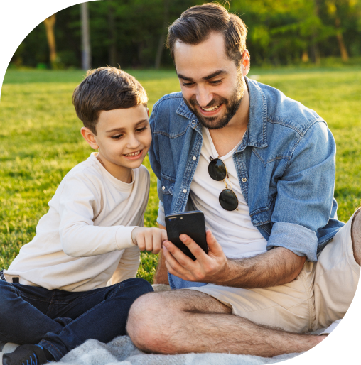 Father and son using a phone to adjust the temperature of a ductless mini-split heat pump in their home